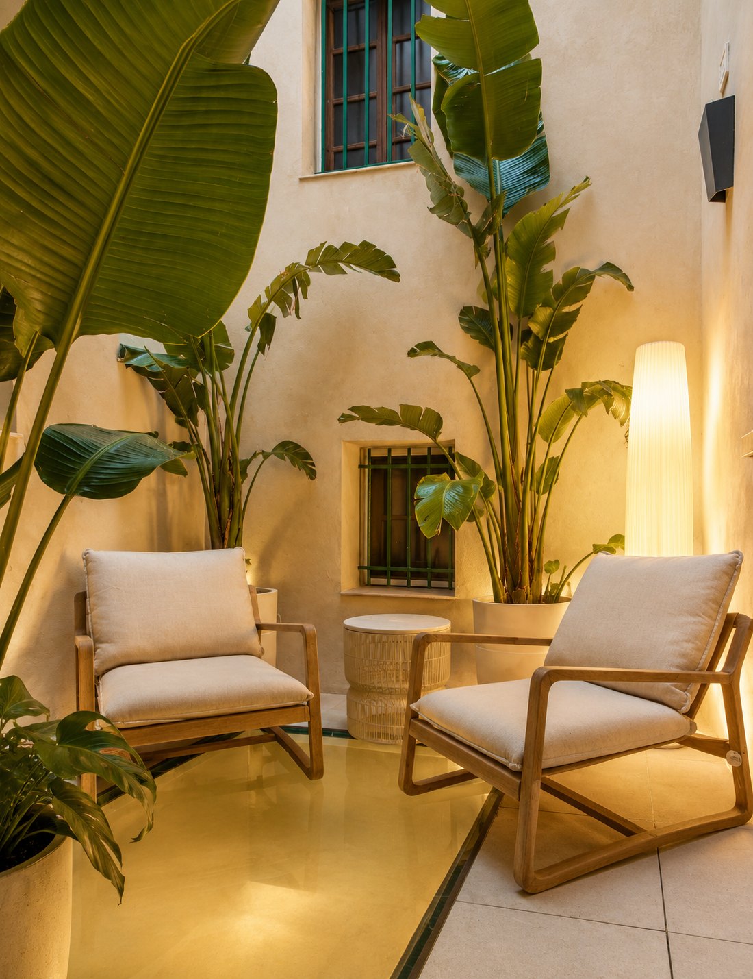 Patio de CasaKary con butacas y plantas al anochecer